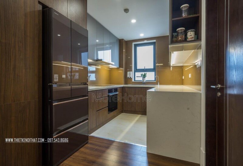 Phòng bếp thu hút ánh nhìn bởi mẫu tủ bếp gỗ công nghiệp và sự kết hợp giữa màu sắc của tủ cùng với kính màu ốp bếp màu vàng. Mẫu nội thất chung cư đẹp